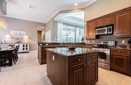 Central Naples House | Briarwood Upscale home with two primary suite-heated pool & spa- entertaining area w/TV